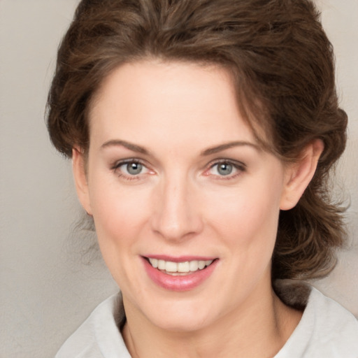 Joyful white young-adult female with medium  brown hair and green eyes