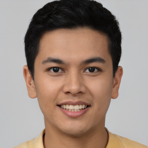 Joyful latino young-adult male with short  black hair and brown eyes