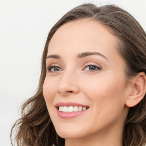 Joyful white young-adult female with long  brown hair and blue eyes