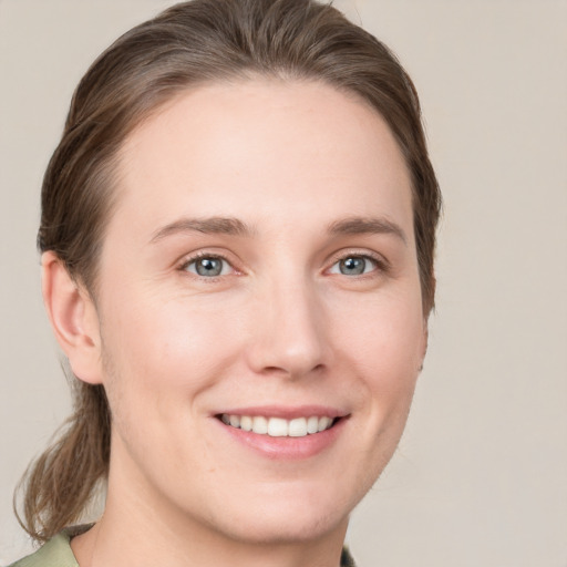 Joyful white young-adult female with medium  brown hair and grey eyes