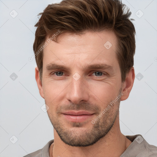 Joyful white young-adult male with short  brown hair and grey eyes