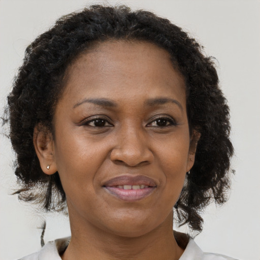 Joyful black adult female with medium  brown hair and brown eyes