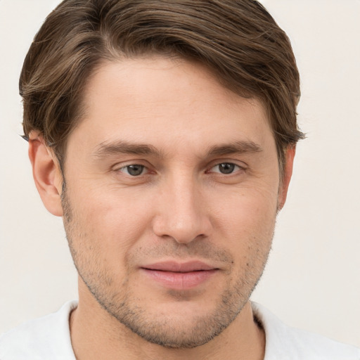 Joyful white young-adult male with short  brown hair and grey eyes