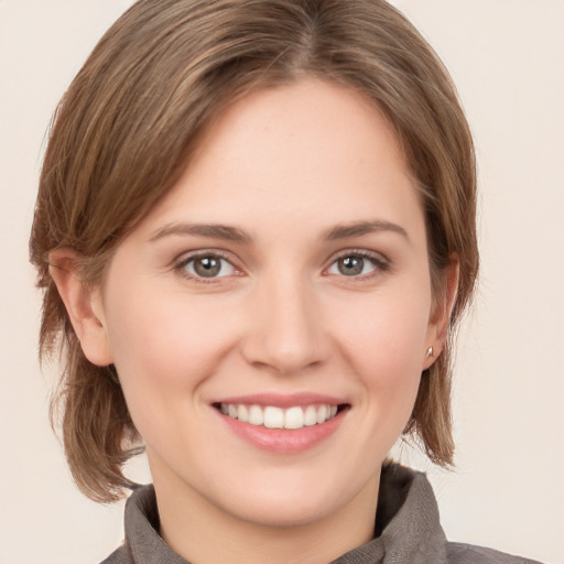 Joyful white young-adult female with medium  brown hair and grey eyes