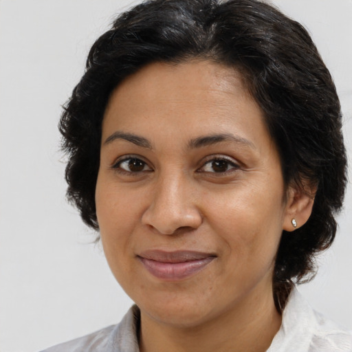 Joyful latino adult female with medium  brown hair and brown eyes