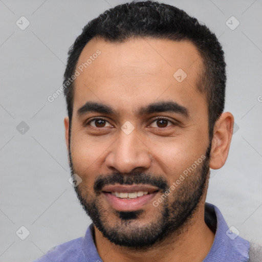 Joyful latino young-adult male with short  black hair and brown eyes