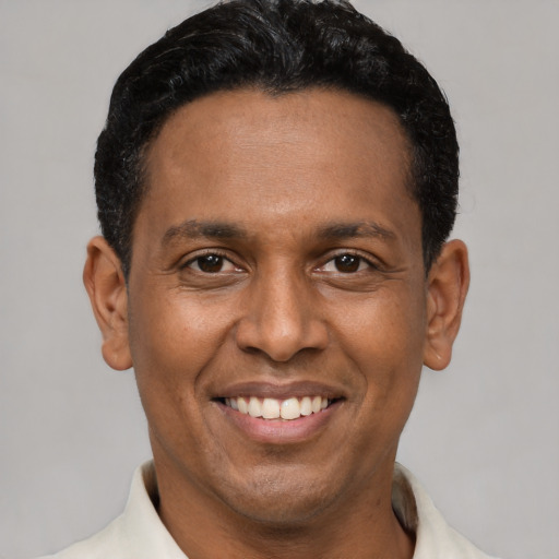 Joyful latino young-adult male with short  black hair and brown eyes