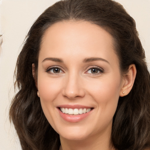 Joyful white young-adult female with long  brown hair and brown eyes