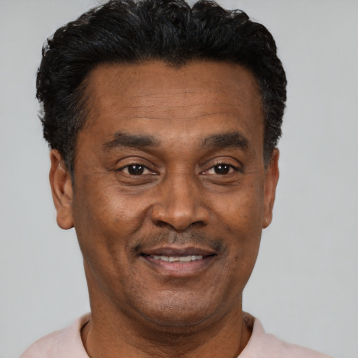 Joyful black adult male with short  black hair and brown eyes