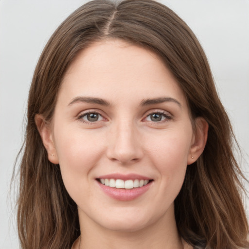 Joyful white young-adult female with long  brown hair and grey eyes