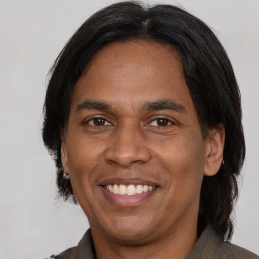 Joyful latino adult male with medium  black hair and brown eyes