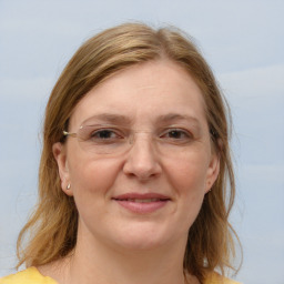 Joyful white adult female with medium  brown hair and blue eyes