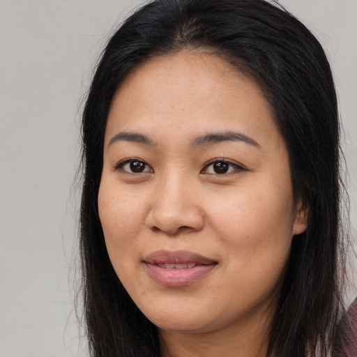 Joyful asian young-adult female with long  brown hair and brown eyes