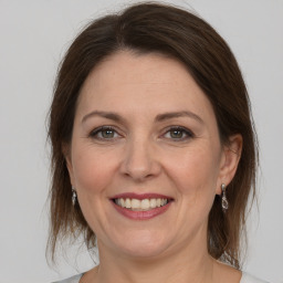 Joyful white adult female with medium  brown hair and grey eyes