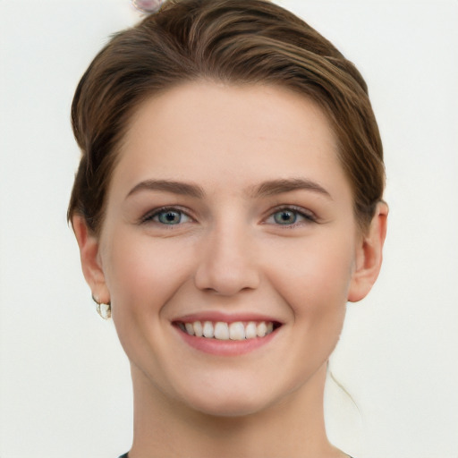 Joyful white young-adult female with short  brown hair and grey eyes