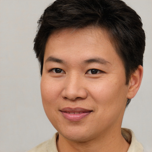 Joyful asian adult male with short  brown hair and brown eyes