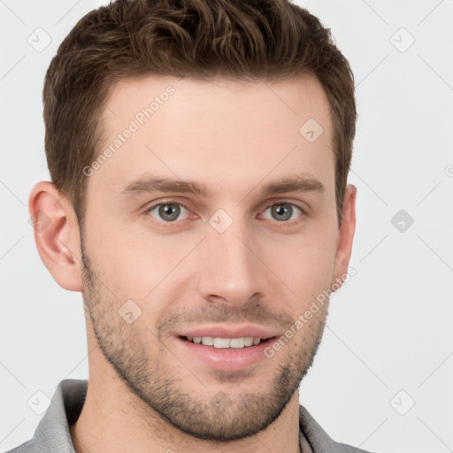 Joyful white young-adult male with short  brown hair and grey eyes