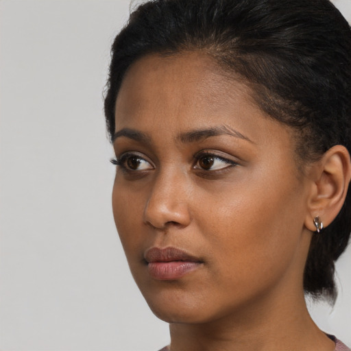Neutral black young-adult female with medium  brown hair and brown eyes