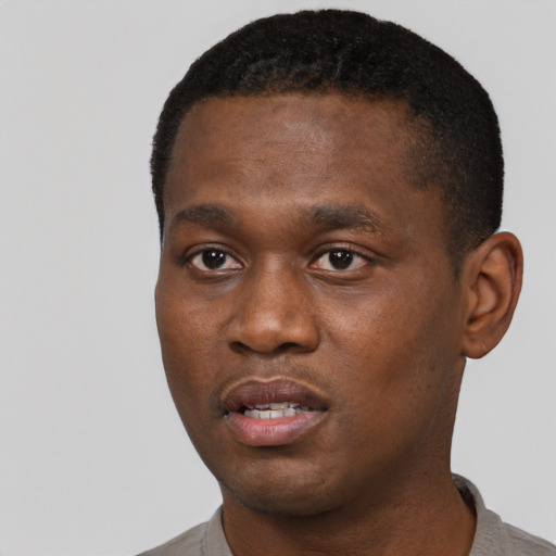 Joyful black young-adult male with short  black hair and brown eyes