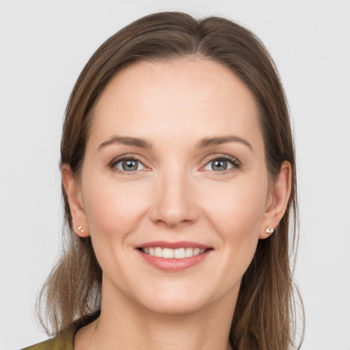 Joyful white young-adult female with long  brown hair and grey eyes