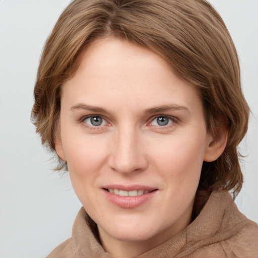 Joyful white young-adult female with medium  brown hair and blue eyes