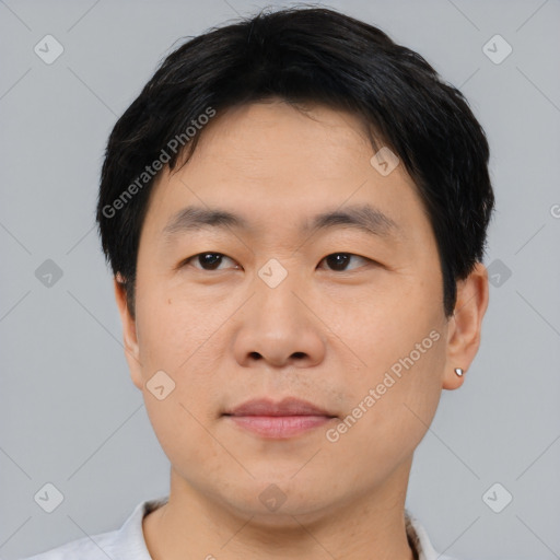 Joyful asian young-adult male with short  black hair and brown eyes