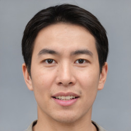 Joyful asian young-adult male with short  brown hair and brown eyes