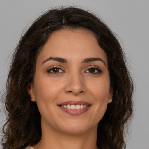 Joyful white young-adult female with long  brown hair and brown eyes