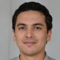 Joyful white young-adult male with short  black hair and brown eyes