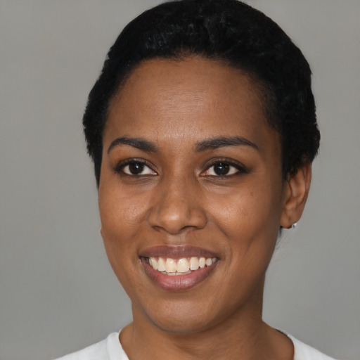 Joyful black young-adult female with short  black hair and brown eyes