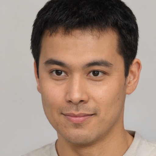 Joyful asian young-adult male with short  black hair and brown eyes