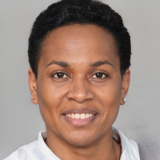 Joyful black adult female with short  black hair and brown eyes