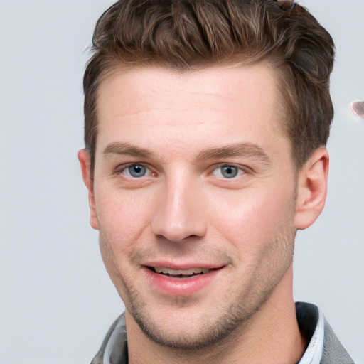 Joyful white young-adult male with short  brown hair and blue eyes