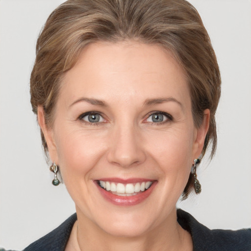 Joyful white adult female with medium  brown hair and grey eyes