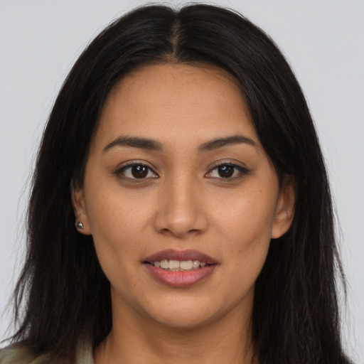 Joyful latino young-adult female with long  brown hair and brown eyes