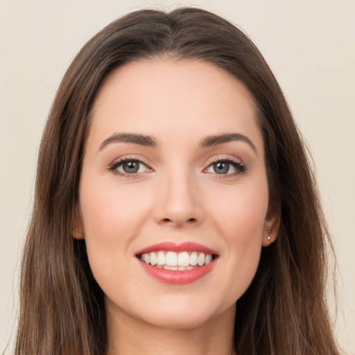 Joyful white young-adult female with long  brown hair and brown eyes