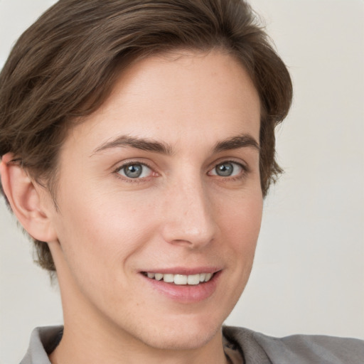 Joyful white young-adult female with short  brown hair and grey eyes