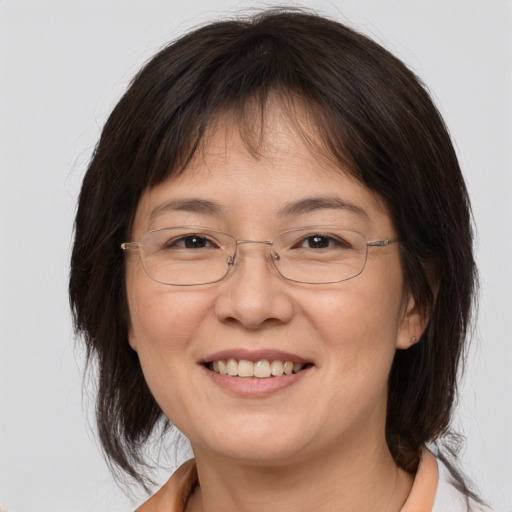 Joyful white adult female with medium  brown hair and brown eyes