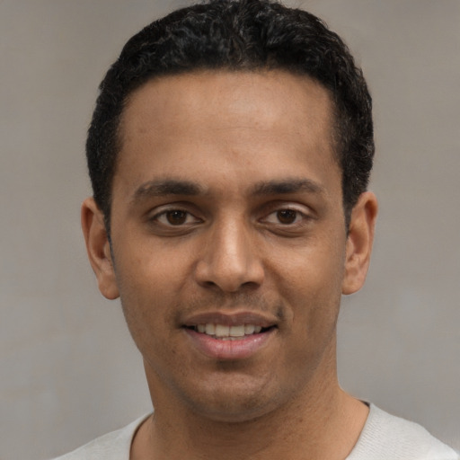 Joyful white young-adult male with short  black hair and brown eyes