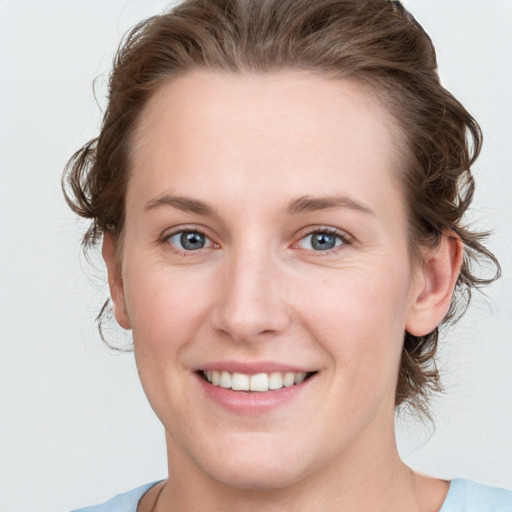 Joyful white young-adult female with medium  brown hair and blue eyes