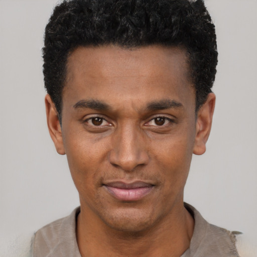 Joyful black young-adult male with short  black hair and brown eyes