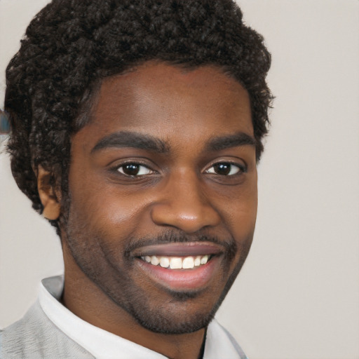 Joyful black young-adult male with short  brown hair and brown eyes