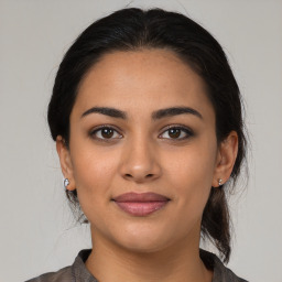 Joyful latino young-adult female with medium  brown hair and brown eyes