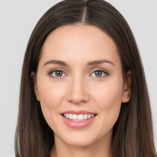 Joyful white young-adult female with long  brown hair and brown eyes