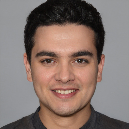 Joyful white young-adult male with short  black hair and brown eyes