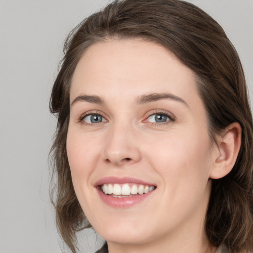 Joyful white young-adult female with medium  brown hair and green eyes