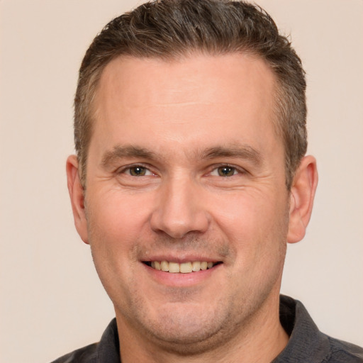 Joyful white adult male with short  brown hair and brown eyes