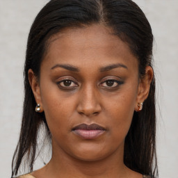 Joyful black young-adult female with long  brown hair and brown eyes