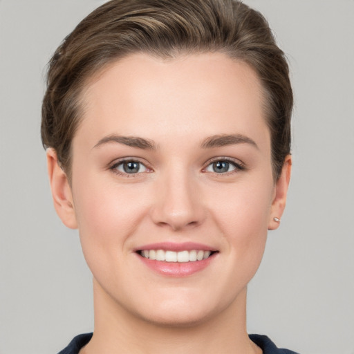 Joyful white young-adult female with short  brown hair and grey eyes