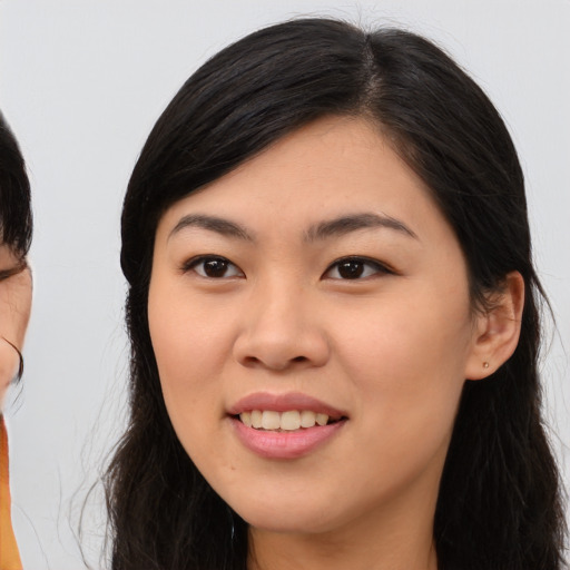 Joyful asian young-adult female with long  brown hair and brown eyes